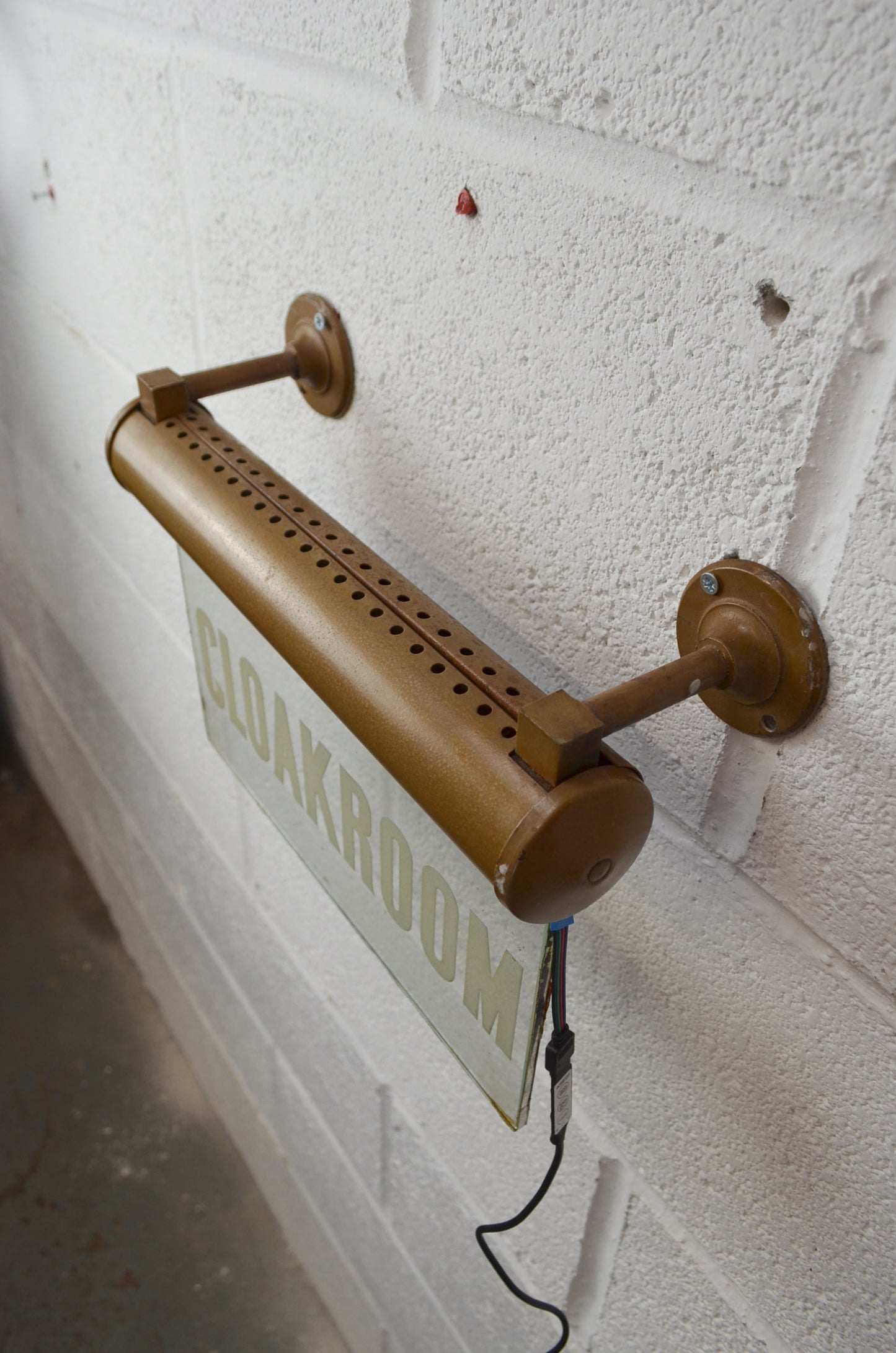 A CLOAKROOM illuminated 'Internalite' directional sign