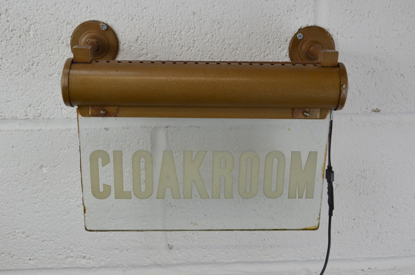 A CLOAKROOM illuminated 'Internalite' directional sign