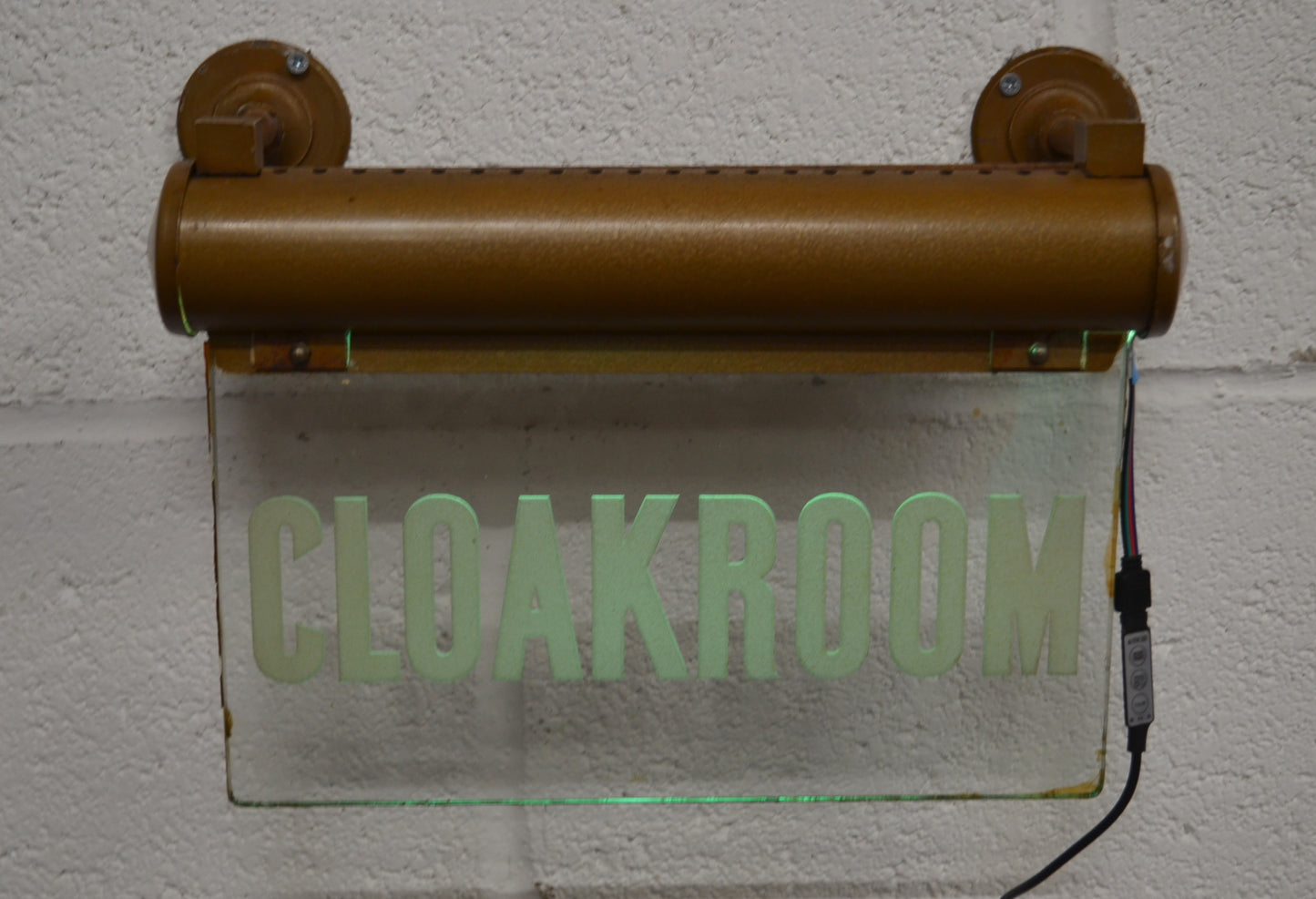 A CLOAKROOM illuminated 'Internalite' directional sign