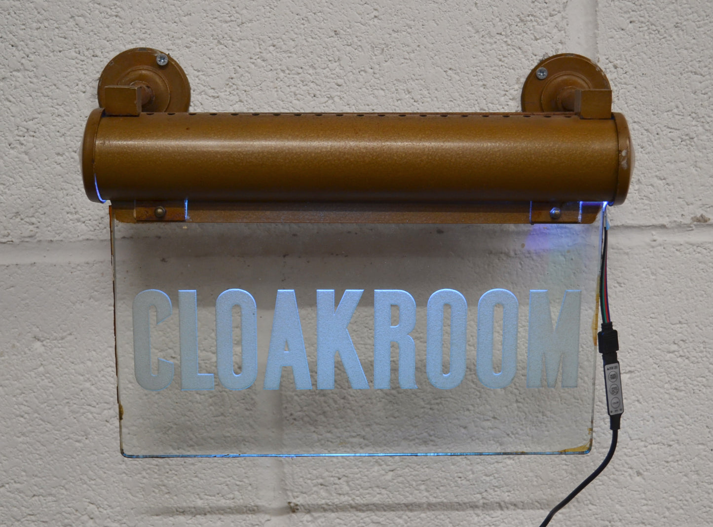 A CLOAKROOM illuminated 'Internalite' directional sign