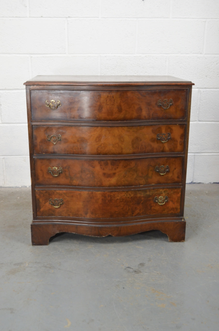 An early 20th century burr walnut/mahogany chest of four drawers with serpentine front and original handles