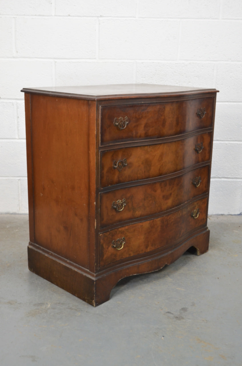 An early 20th century burr walnut/mahogany chest of four drawers with serpentine front and original handles